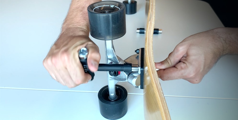 Using a skate tool to tighten the hardware on a longboard Tighten Longboard Hardware